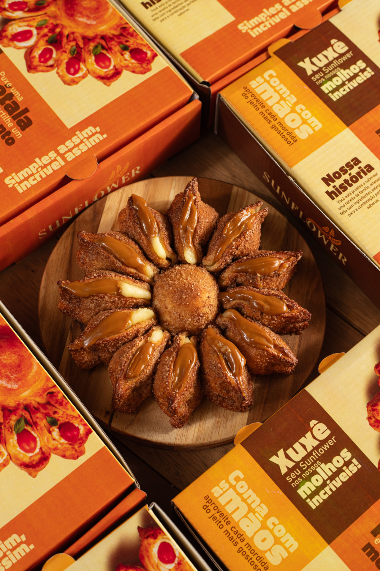 Girassol Sunflower recheado com doce de leite ao lado das embalagens da marca